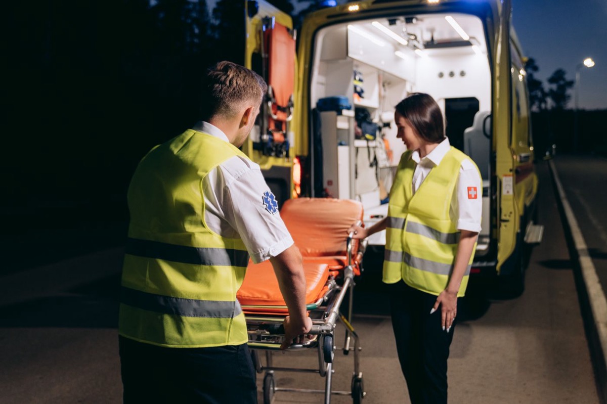 Ambulance crew working on scene at night